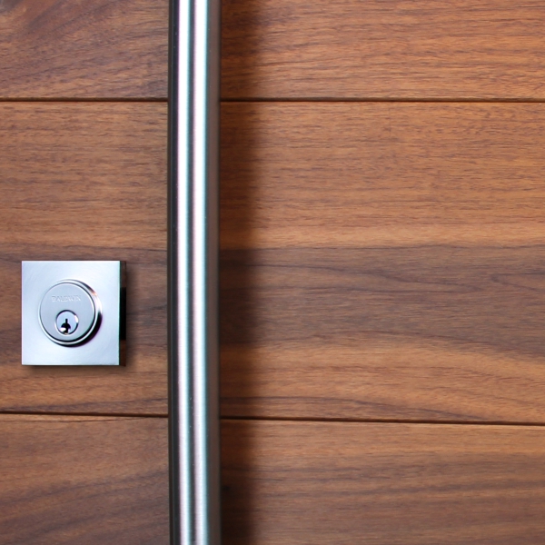 An exterior wood door with stainless steel door handles and lock