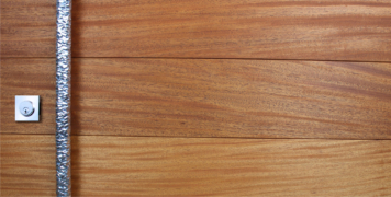 mahogany hardwood behind hammered and polished custom door pulls and stainless square baldwin lock