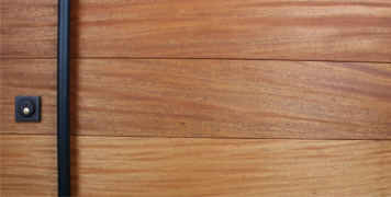 mahogany hardwood front door with round black powder-coated door handles and matching baldwin black lock