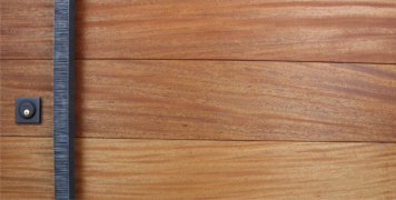 mahogany hardwood door behind hand-serrated square custom door handles and black square door lock