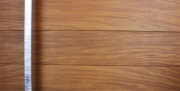 teak wooden front door behind square polished door hardware