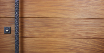 teak wooden door behind round hammered door pulls and black square baldwin door lock
