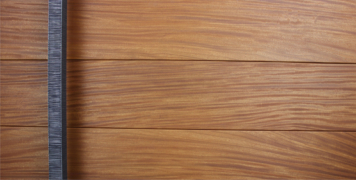 teak wooden front door behind square serrated custom door handles
