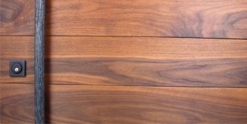 walnut wooden door behind custom round door handles and baldwin black square lock