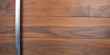modern front door made of genuine walnut wood and polished round door hardware