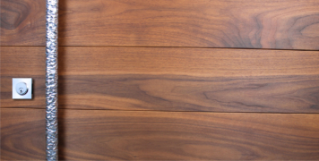real walnut wood behind polished hammered door handles and square stainless steel door lock