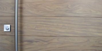 real washed teak wood door behind stainless steel round door hardware and stainless steel door lock