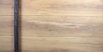 white oak wooden entry door behind dark round door hardware