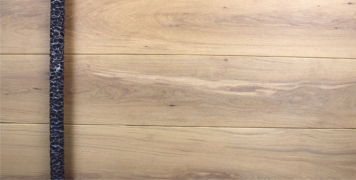 white oak wooden luxury front door behind round dark textured door pull