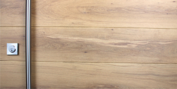 white oak hardwood behind stainless steel round door handle and stainless steel square door lock
