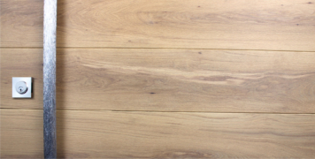 white oak hardwood door behind modern door handles and stainless steel door lock