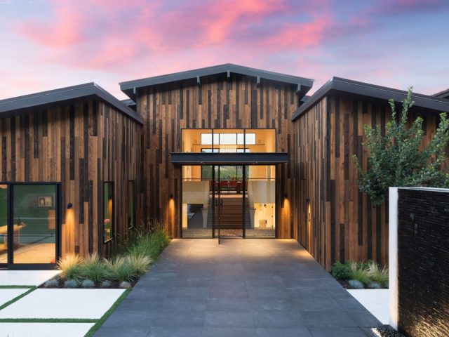 stunning modern home with a rustic wood exterior and a sleek glass front door, perfect for contemporary living