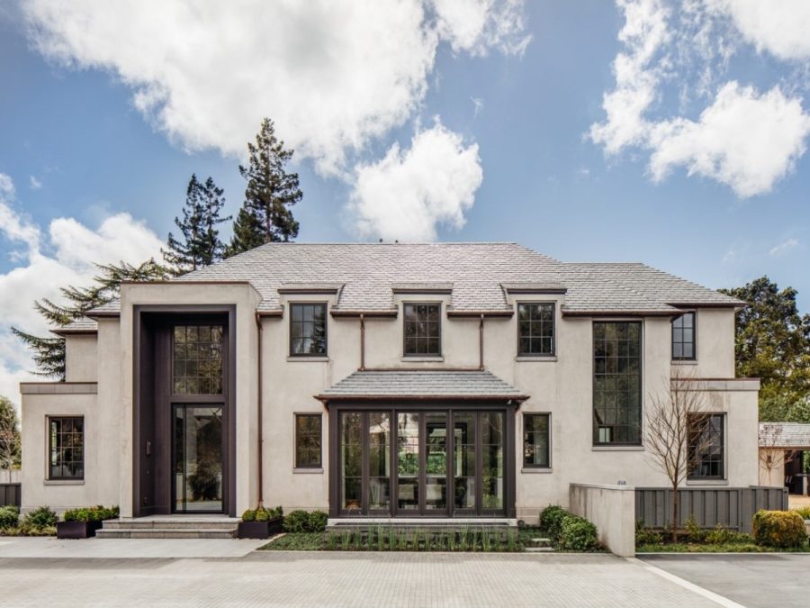 elegant modern mansion with formal facade, large windows, flat roof accents, and a grand glass front door