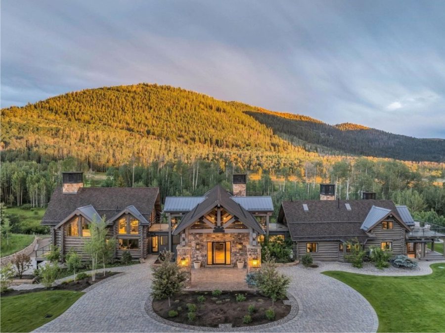 luxury mountain retreat with log cabin design, stone accents, scenic views, and a paved circular driveway