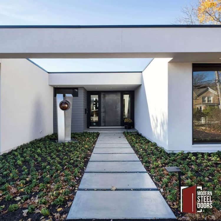 modern home with treated raw steel pivot door and glass sidelights in white facade